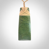 Hand carved from a lovely piece of local New Zealand Jade. We have suspended this from a 3-plait beige cord which can be adjusted with a couple of slip knots and beige binding.
